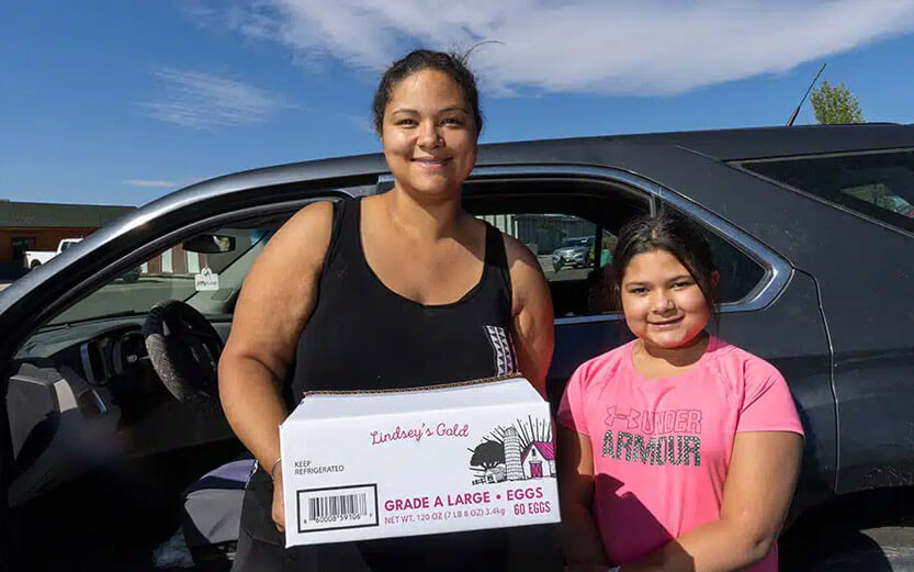 a mother and daughter holding a box of eggs