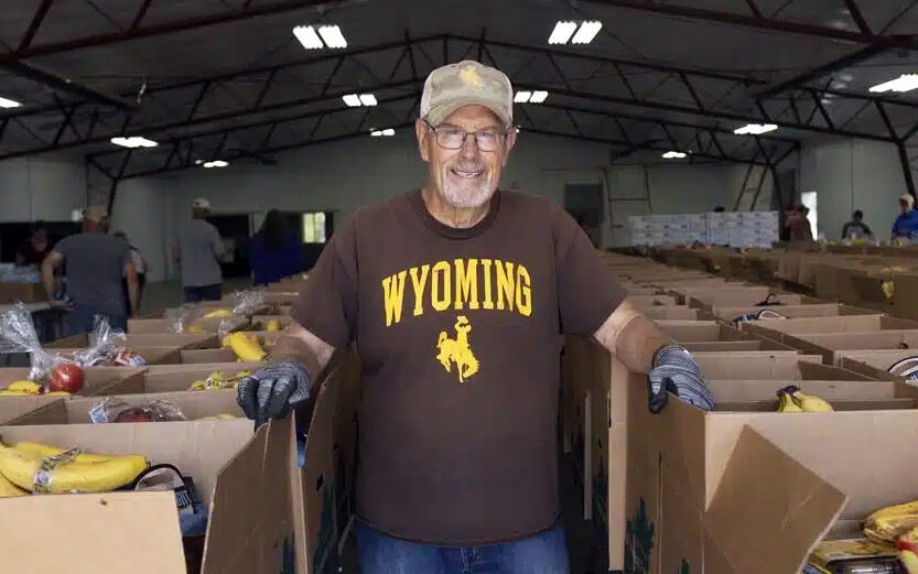 a food bank volunteer in the warehouse wearing a Wyoming tshirt and smiling