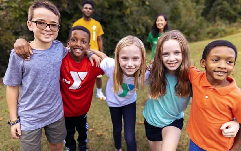 a group of kids outside smiling