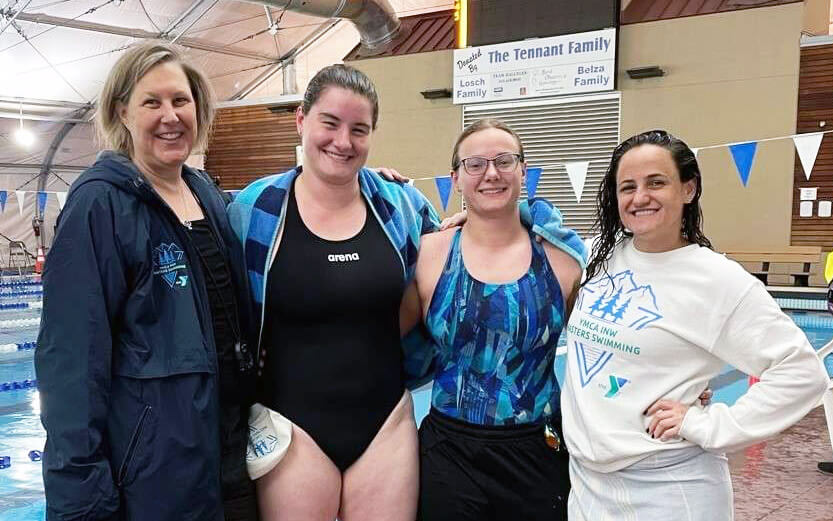 four adult female swimmers smiling