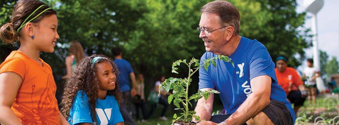 a Y volunteer teaching gardening to kids